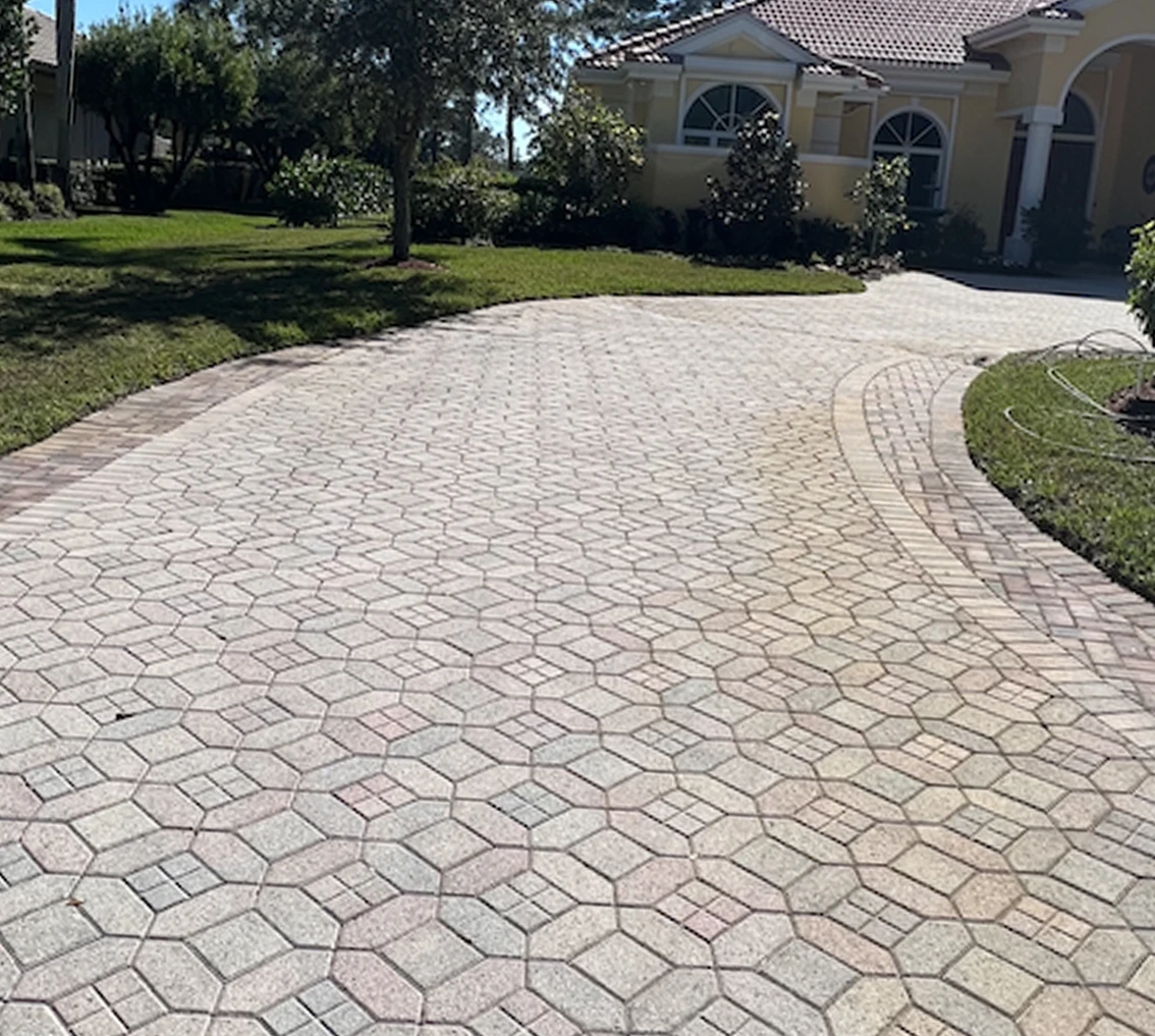 Paver driveway showcasing faded colors and uneven surface, highlighting the need for professional tinting services to restore vibrancy and enhance outdoor aesthetics.