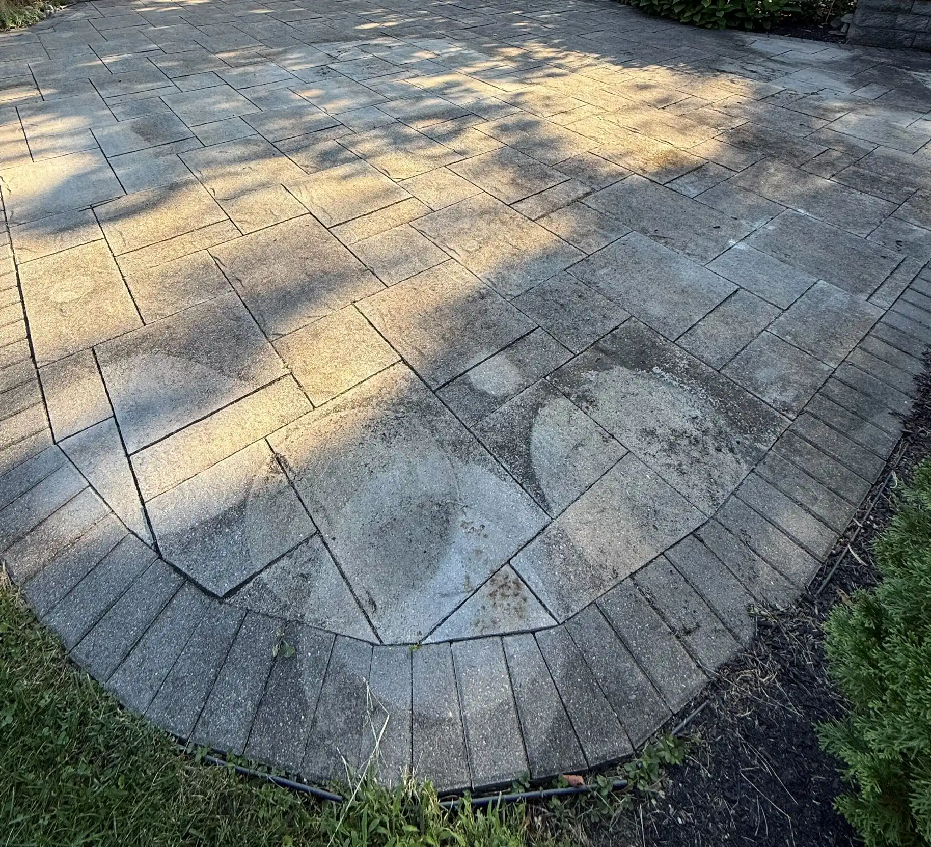 Uneven and worn pavers on a patio, showcasing signs of weathering and discoloration, highlighting the need for restoration services in Ohio.